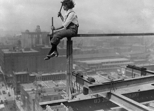 Worker sitting high atop skyscraper framing